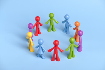 . Toy people on a blue background. People form a working group around an idea or task. Team...