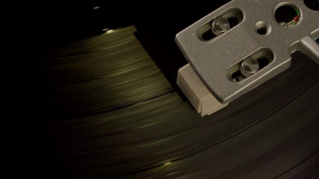 Close-up pickup head on vinyl record spinning on turntable. Top view. Concept of record collectors, vinyl lovers fans, fanatic, guide, FAQ, advice, top, home audio, tangibles, cool again, old-school
