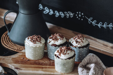 close-up chocolate muffins with creamy cottage cheese cream and chocolate chips sprinkled on a black background