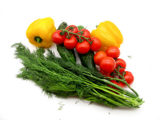 Vegetables: sweet yellow peppers, red cherry tomatoes, green cucumbers and dill on a white background.