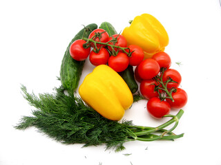 Vegetables: sweet yellow peppers, red cherry tomatoes, green cucumbers and dill on a white background.