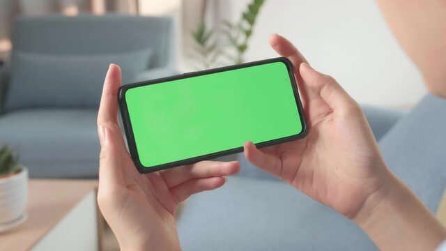 Hands Female Holding Smartphone With Green Screen In Living Room 