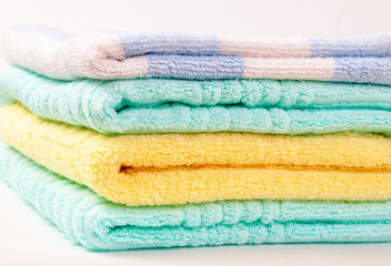 A stack of multi-colored terry towels folded in a pile