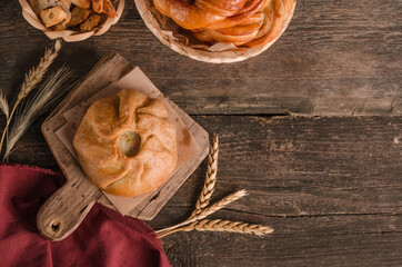 Appetizing fresh culinary pastry - beautiful curly pie on a wooden background with copy space