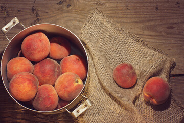 A saucepan full of ripe peaches stands on the table