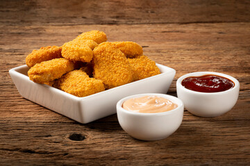 Fried chicken nuggets with ketchp and rose sauce.