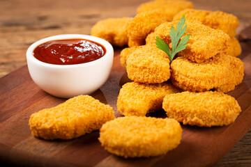 Fried chicken nuggets with ketchp and rose sauce.