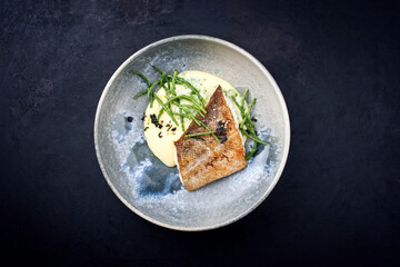 Modern style traditional fried skrei cod fish filet with mashed potatoes and sea asparagus served...