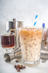 Set with different iced summer coffee drinks - espresso, frappe, latte, cappuccino, with whipped cream, syrup and crushed ice, in various glasses and mugs on white background copy space