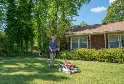 Man Cutting Grass In Summer