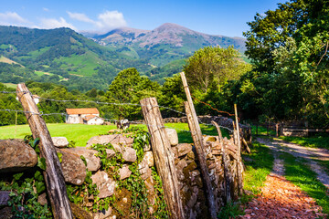 Casa de campo en prado del Valle del Baztan de Navarra tras muro de piedra. Navarra. España