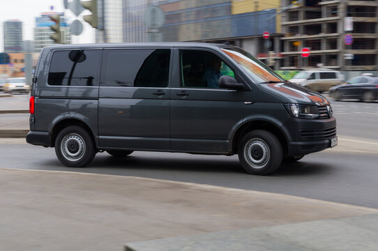 Fast moving Volkswagen Transporter T5 on the city road. Red VW multivan  riding on street. Commercial auto in fast motion with blurred background.  Stock Photo