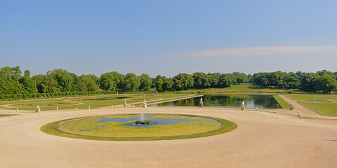 Gardens of Chantilly castle, with lakes and fountains on a sunny day, Oise, France