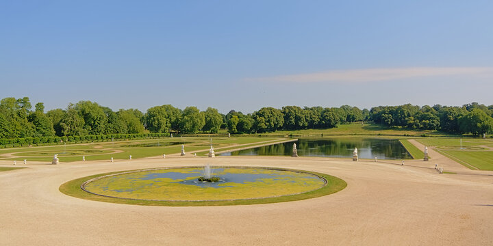 Gardens of Chantilly castle, with lakes and fountains on a sunny day, Oise, France