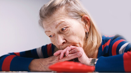 hopeless elderly woman looking at the empty wallet. High quality photo