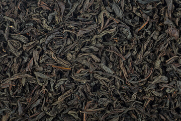 Background texture of dried black tea leaves. Chinese tea. Large dry leaves of black tea.