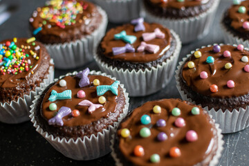 Chocolate cupcake muffins decorated with colourful sprinkles 