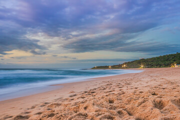 Overcast cloudy sunrise over a rough Indian Ocean from a view point on a beach in Port Shepstone,...