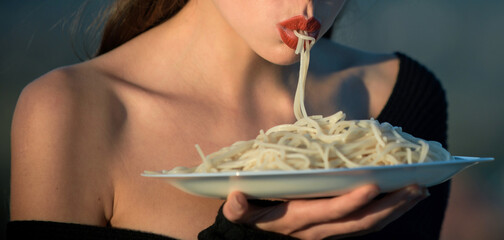 Woman with red lips eat pasta. Hunger, appetite, recipe. Sensual lips suck pasta. Italian macaroni...