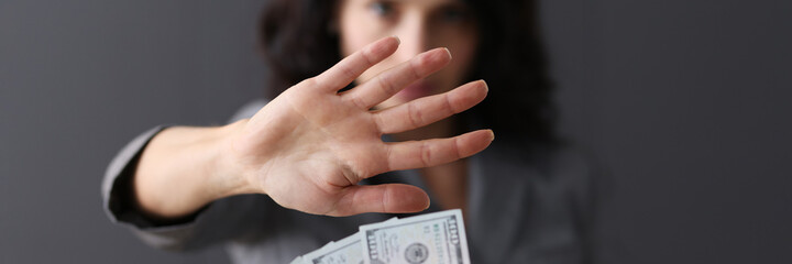 Business woman with hand refusing offered money closeup