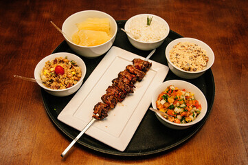 kebab cattle barbecue with side dishes on a wooden table