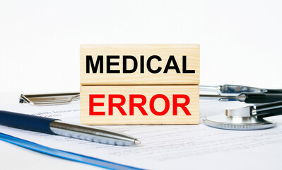 Wooden blocks with text Medical Errors on a clipboard, stethoscope and pen