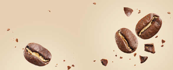 Close-up of roasted beans flying in the air among ground coffee on a beige background. Concepts of levitation. The crash coffee shatters into pieces. banner with copy space.