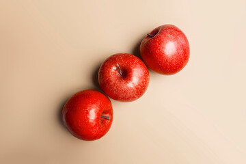 top view of 3 red apples on cream colored background