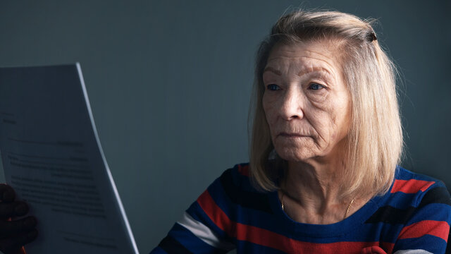 Worried elderly woman reading doctor report. . High quality photo