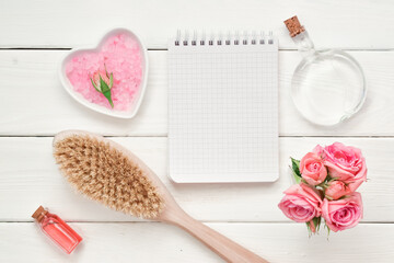 Checkered notebook and wooden brush with cosmetics and perfume. The scheduler. To-do list. Empty space. Massage Flatt was lying down. Top view.