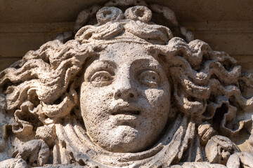 Obraz premium Visage de femme sculpté en pierre, probablement une allégorie de la fortune, ornement de façade d'un immeuble ancien de Paris, France
