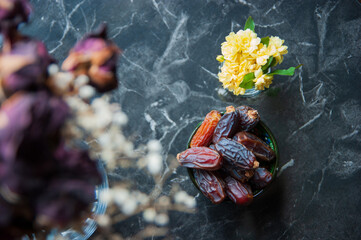 Top view of a composition with dried iftar dates, yellow flowers and dried roses