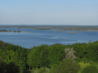 landscape background: green forest, river with islands and blue sky