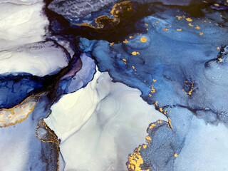 Abstract blue art with gold — fluid background with beautiful smudges and stains made with alcohol ink and golden pigment. Blue with violet texture resembles natural materials, watercolor or aquarelle