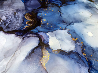 Abstract blue art with gold — fluid background with beautiful smudges and stains made with alcohol ink and golden pigment. Blue with violet texture resembles natural materials, watercolor or aquarelle