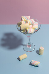 Colorful marshmallows in a martini glass. Pastel blue and pink colors. Top view