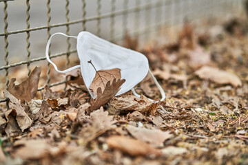 ffp2 mask in front of the fence. fence is a symbol for the lockdown and isolation