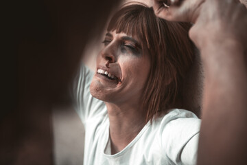 Close-up of a man from behind, hitting with a crying woman to a dirty wall