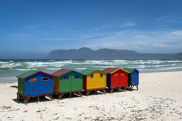 Famous colorful beach houses in Muizenberg near Cape Town, South Africa with mountains of Cape of...