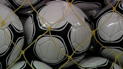 Worker putting Soccer Balls into a Net Bag in a Soccer Ball Factory in Argentina. Low Angle View. Zoom In.  