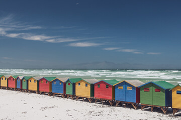 Naklejka premium Famous colorful beach houses in Muizenberg near Cape Town, South Africa with Hottentots Holland mountains in the background.