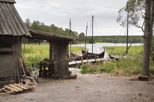 Traditional viking age village. Birka, Bj&ouml;rk&ouml; island, lake M&auml;laren, Sweden. House (shed), wooden sailboats. Atmospheric landscape. Landmarks, sightseeing, history, historical reenactment, craft