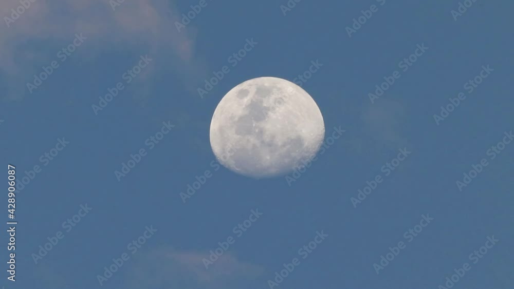 Poster an almost full moon with clouds passing in the late evening.