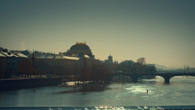national theather in Prague unde bright sunlight under charles bridge