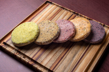Vegan and vegetarian assorted legume and vegetable burgers of different colors on wooden board for a healthy and healthy life