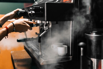 Fototapeta na wymiar hands of an unrecognizable person manipulating a coffee machine.