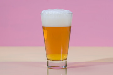 A glass full of beer with white foam 