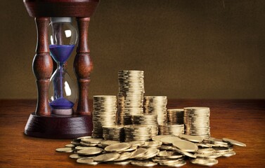 Sand running through the bulbs of an hourglass on the desk