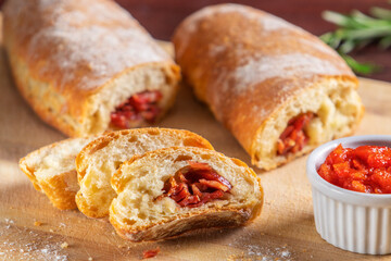 Fatias de pão recheado com calabresa acompanhadas de pasta de tomate.