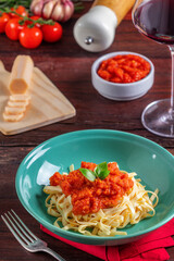 Fettuccine ao molho de tomate, decorado com folhas de manjericão